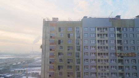 Construction of a multi-storey building in winter. Multi-storey building at the stage of finishing outside, winter season.の写真素材