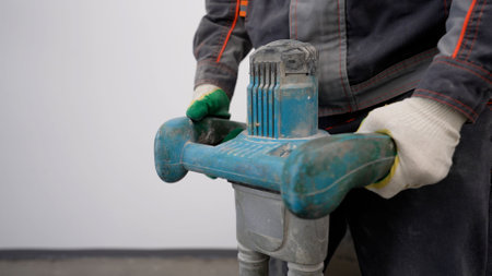 Mixing concrete. A bucket of gray mixing and mixing solution for on-site work. Tool rotation in...
