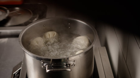 Khinkali are thrown into the pan. Khinkali or dumplings were thrown to cook in a transparent pot with water.の写真素材