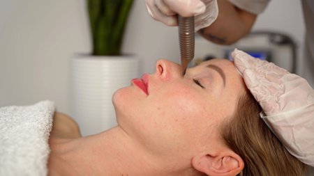 Woman getting laser face treatment. Woman at the spa getting a facial laser treatment. Cosmetologist...