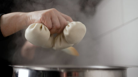 Khinkali are thrown into the pan. Khinkali or dumplings were thrown to cook in a transparent pot with water.の写真素材