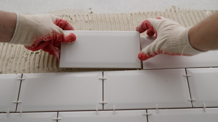 Laying backsplash tiles in the kitchen. Tile apron in the kitchen. White tiles, leveling clips, tile...
