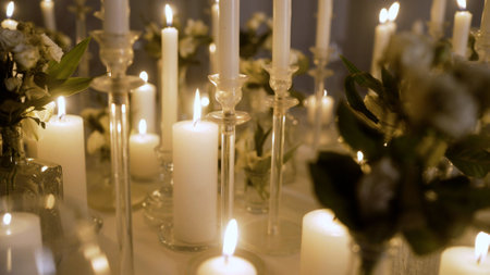 Table with candles, no people. Warm light of candles on a wooden table at night.Scented candles in ceramic bowls on a linen tablecloth on the table.の写真素材