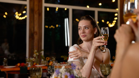 Friends celebrating with raised glasses at festive party.の写真素材