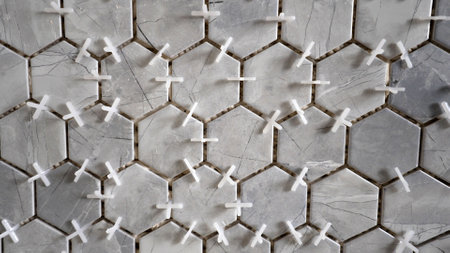Mosaic tiles in the kitchen, gray. Installing cross fasteners on ceramic tiles on the wall. New porcelain tiles with leveling spacers for grouting.の写真素材