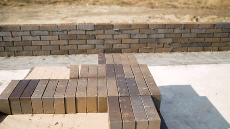 Concept of building a house from bricks. New bricks on a house construction. Bricks stacked in a row, ready for transportation, brick warehouse.の写真素材