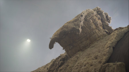 Light from the sun illuminates a decaying thatch roof, highlighting its vulnerability to the elements and emphasizing the need for repair or replacementの写真素材