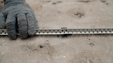 Construction worker reinforcing cement screed, using metal lath on floor with precision and...