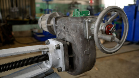 Close-up of a complex gearbox featuring a large wheel, screw mechanism, and motor, showcasing...