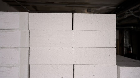 Professional construction workers installing aerated concrete blocks for interior wall construction in new residential apartment developmentの写真素材