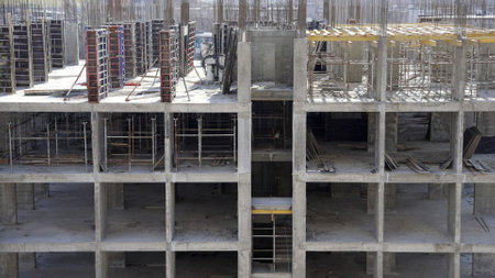 Construction workers are installing a concrete floor slab in a new building, showcasing the progress...