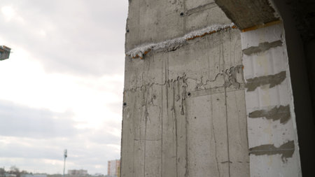 Structural concrete wall revealing construction defects and potential integrity issues during urban development projectの写真素材