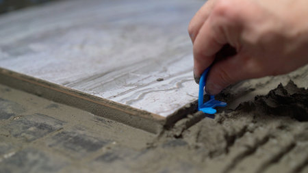 Construction worker placing tile spacers during floor renovationの写真素材