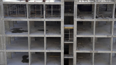 Concrete building skeleton rising floor by floor on a construction site, showcasing ongoing progress