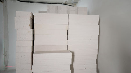 Professionally stacked white concrete blocks waiting at construction site, showcasing building materials ready for architectural project with precise arrangementの写真素材