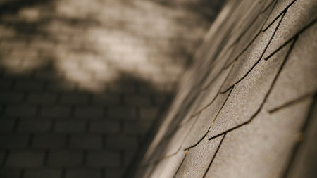 Sunlight glide over the roofs bitumen shingles. Installing a shingle roof on a house.の写真素材