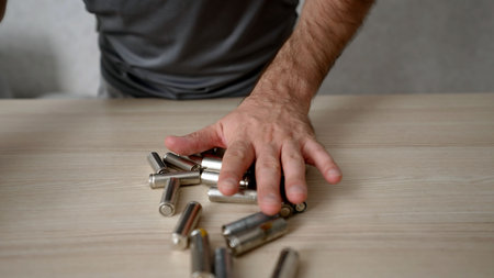 Numerous used and discharged alkaline batteries arranged in rows. A depiction of battery recycling, electronic waste management and environmental pollutionの写真素材