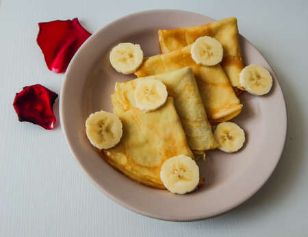 pancakes on a plate with banana slicesの写真素材