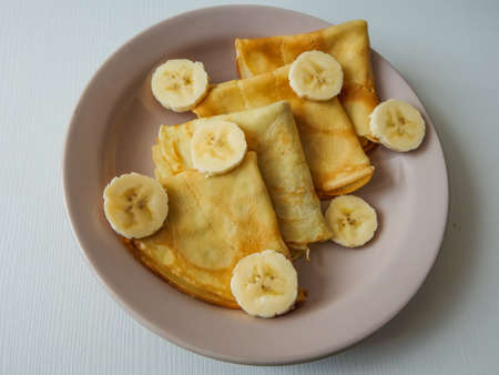 pancakes on a plate with banana slicesの写真素材