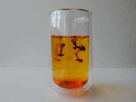 water in a glass colored with manganese, beautiful patternsの写真素材
