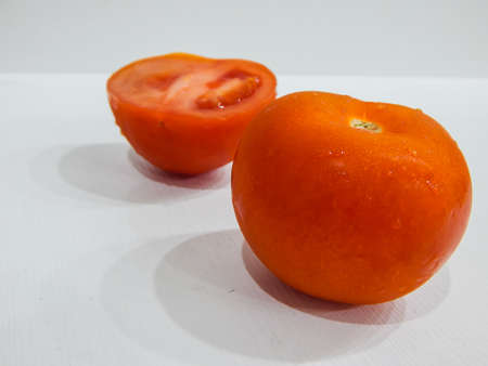 fresh tomatoes with water drops, whole and wedgeの写真素材