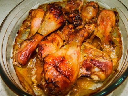 baked chicken legs in a glass bowlの写真素材