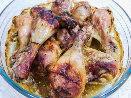 baked chicken legs in a glass bowlの写真素材