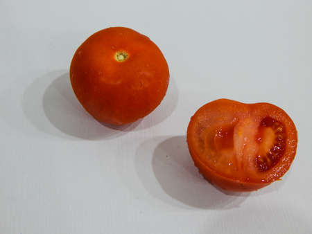fresh tomatoes with water drops, whole and wedgeの写真素材