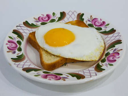 on the plate is an omelet with a piece of bread
