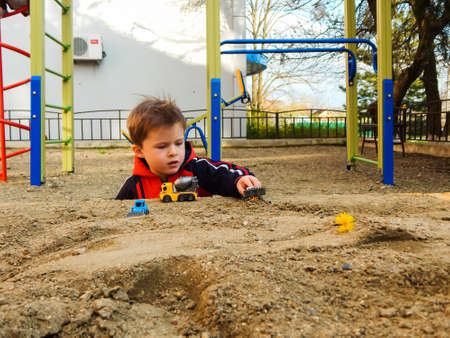 Cute little boy playing in the sandbox on the playground. Early learning.