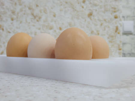 Chicken eggs lie in a tray on a light background