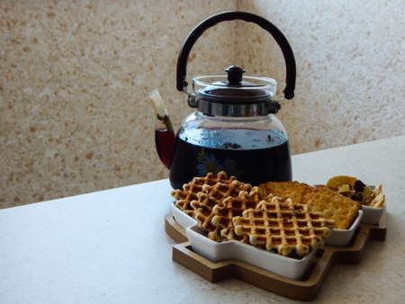 Breakfast with Belgian waffles, black tea and a teapotの写真素材