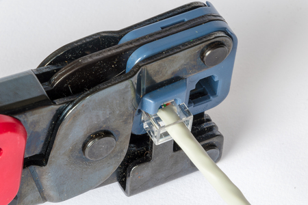 Crimping tool fixing an RJ45 plug to an Ethernet cableの写真素材