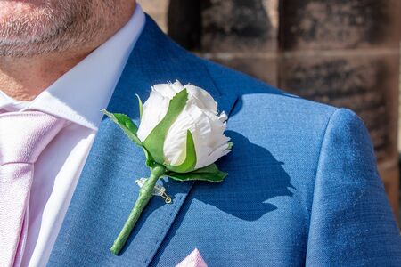 Close view of a groom wearing an artificial rose buttonhole