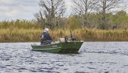 Fisherman on lake in flat-bottomed boatのeditorial素材