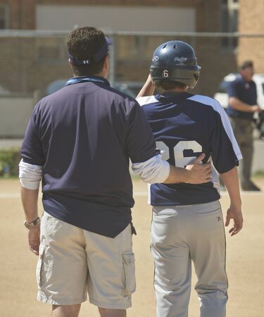 Catholic Middle School Baseball Game. Coach caring for player