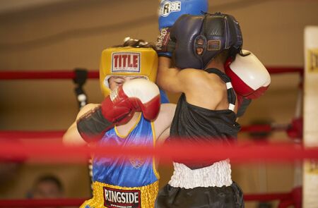  two youth boxers sparing in ring match