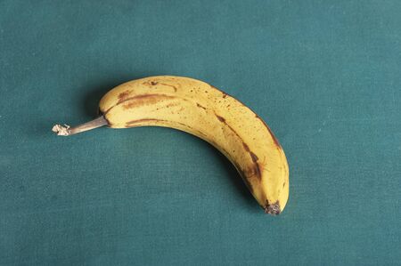 Yellow banana bunch photographed with burlap bag as backdrop. Studio shot.