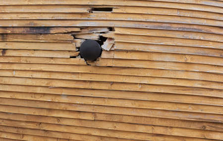 cannon ball in hull of wooden ship