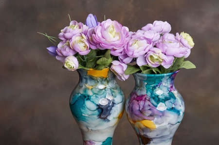 Vase of artificial purple flowers for table decoration