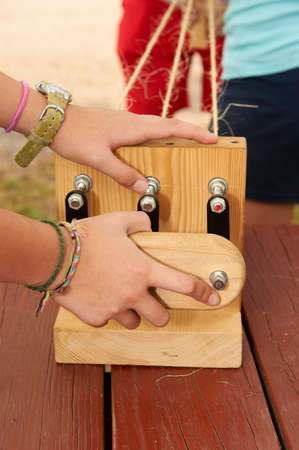 making rope using hand machine at summer camp