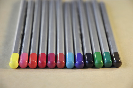 Colourful pencils for art in school on the paper background. Office equipment