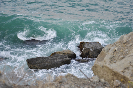Waves crashing on the rocks in the blue ocean. Seascape of the storm and the stones. Big splash at the coast in summerの写真素材
