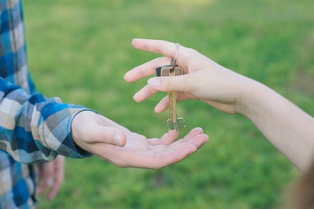 Woman giving a key to the buyer. Concept of house buying deal