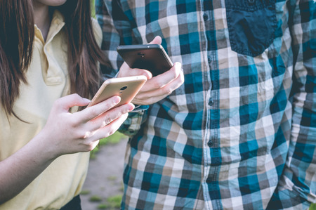 Students using a phone. Teenagers in the social networks sharing onlineの写真素材