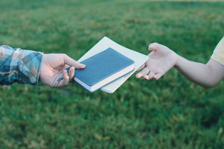 Two students giving each other books and notepad. Friendship exchangeの写真素材