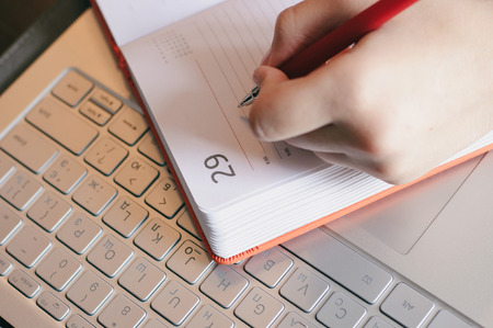 Woman hand writing in the notebook closeup, workplaceの写真素材