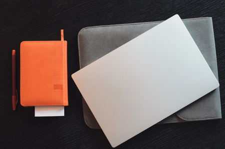 The retina laptop and notebook with pen on the wooden desk in the office, top viewの写真素材
