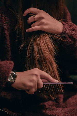 Woman brushing her hair in the morning outdoors. Hairbrush closeupの写真素材