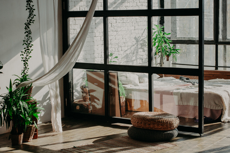 Bedroom loft interior. Bed, pillows, green plant and wall with bricksの写真素材
